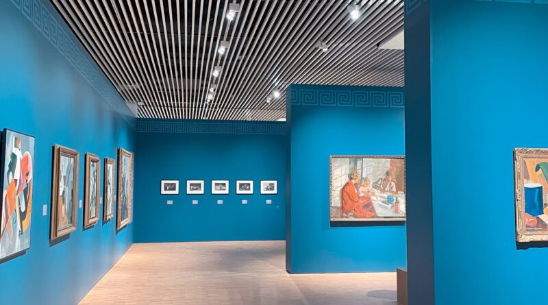 青い壁面に作品が展示された美術館の室内